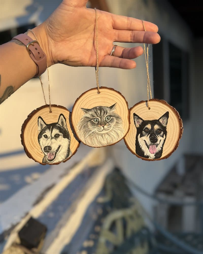 Three hand-painted wood round ornaments — a husky, a fluffy grey cat, and a black-and-tan dog